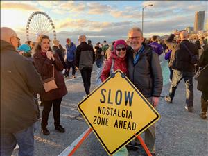 Jared Smith and Karen Daubert on the viaduct with a sign that reads Slow, Nostalgia Zone Ahead